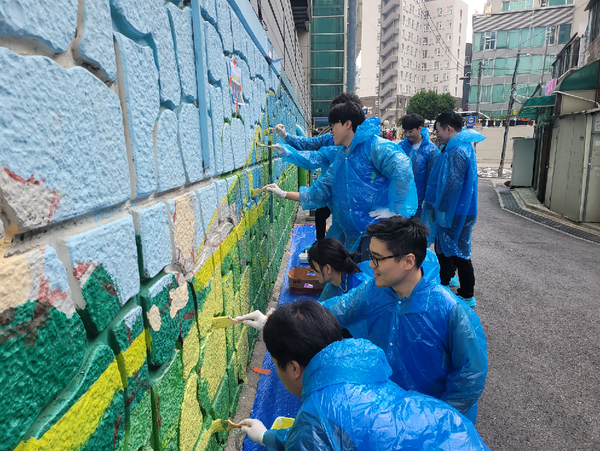 동아쏘시오그룹 임직원들이 서울 동대문구 휘경동 회기역 일대에서 벽화 그리기 봉사활동을 진행하고 있다. 사진=동아쏘시오그룹