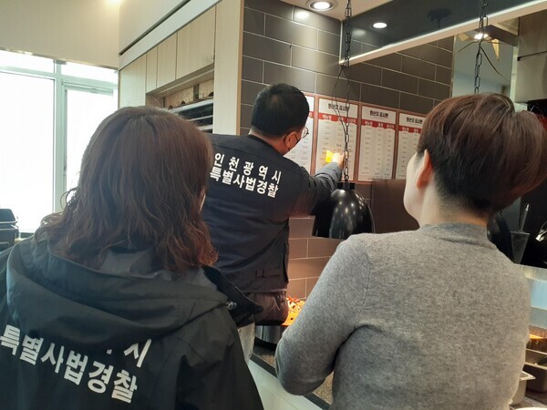 인천광역시 특별사법경찰이 수산물 원산지 표시판을 확인하고 있는 모습 사진=인천광역시