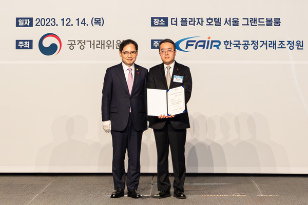 롯데건설 준법경영부문 조도휘 상무(사진 오른쪽)가 한기정 공정거래위원장(사진 왼쪽)으로부터 우수기업 평가증을 수여한 후 기념 촬영을 하고 있다.  사진=롯데건설