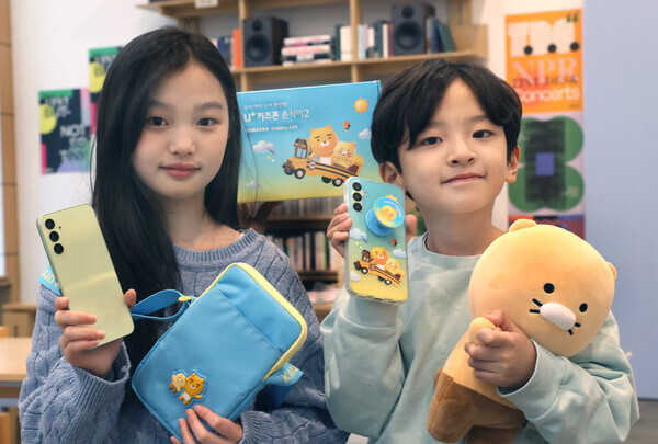 LG유플러스 모델이 카카오 인기 캐릭터 ‘라이언’과 ‘춘식이’ 테마를 적용한 아동 전용 LTE 스마트폰 ‘춘식이2’와 캐릭터 액세서리를 소개하고 있는 모습. 사진=LG유플러스