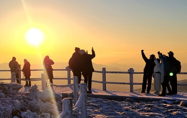 지리산 노고단을 찾은 등산객이 지난 1일 오전 떠오른 2024년 첫 태양을 보며 기념촬영하고 있다. 제공 = 구례군